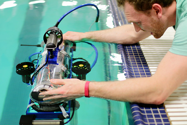 [Picture] Nate holds the AUV steady for another IMU calibration.