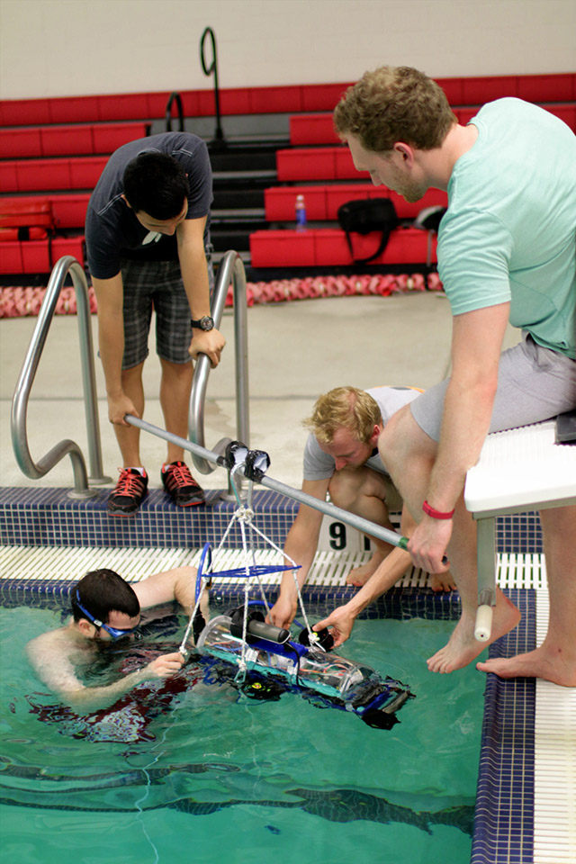 [Picture] Peter secures the four point hoist. After testing, the AUV is lifted out of the water.
