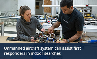 two individuals working on a drone