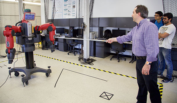 Alan Wagner, assistant professor of aerospace engineering, conducts an experiment with a Baxter robot in the Robot Ethics and Aerial Vehicles Lab