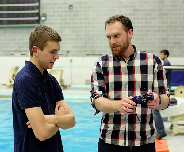 [Photo] Nate explains the hand-held controller buttons to Brandon.